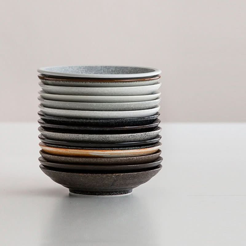 Stack of Japanese-style ceramic deep dishes. Mino yaki tableware in assorted underglaze colors.
